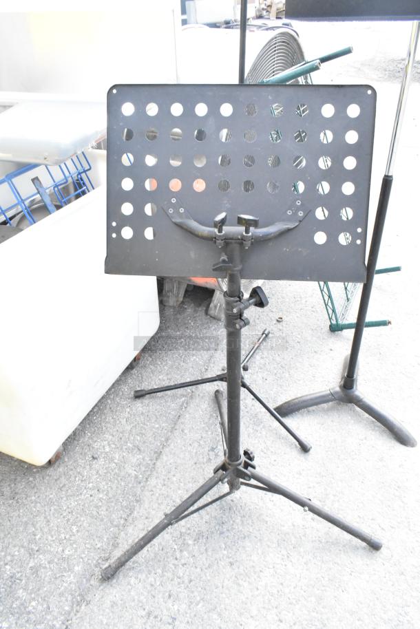 Three adjustable metal stands for auction; used condition, with perforated top panels for holding items.