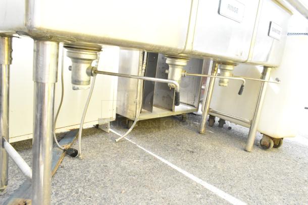 Commercial 3 bay sink with dual drain boards, stainless steel, visible labeling: Rinse, Sanitize; sturdy metal legs.
