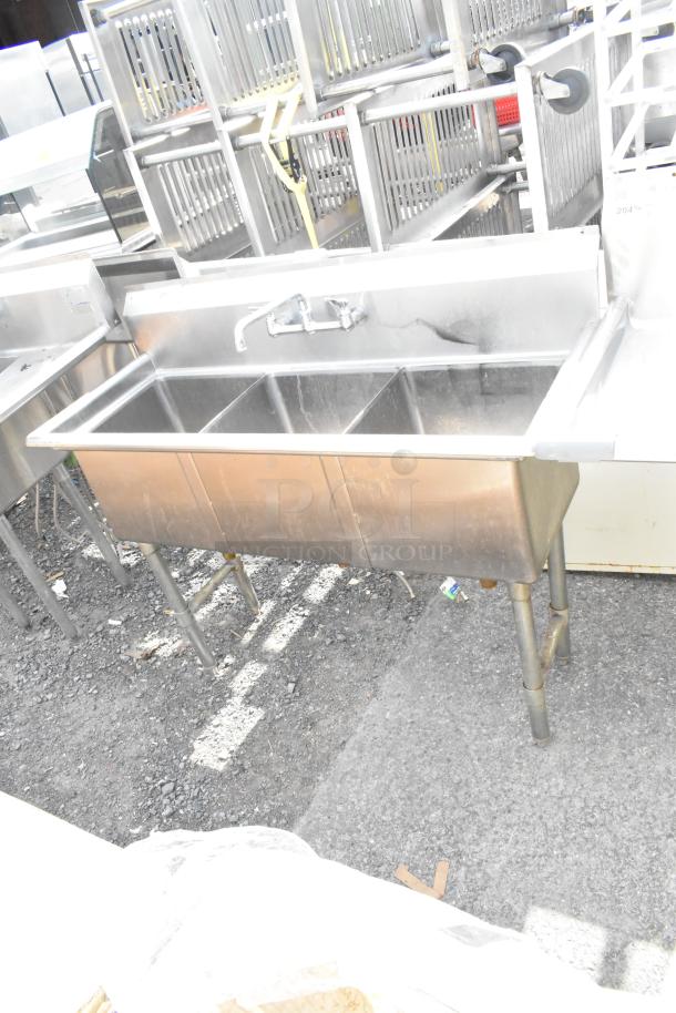 Commercial stainless steel 3 bay sink with faucet, in used condition. Ideal for kitchens or food service settings.