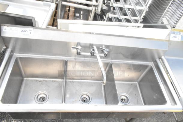 Commercial 3 Bay Sink with stainless steel finish. Features three compartments and a central faucet. Good condition.