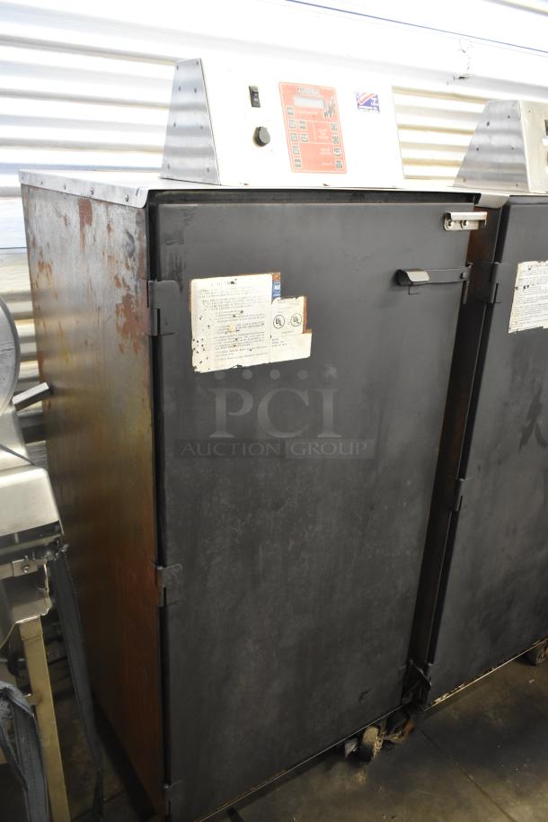 Cookshack 250 Commercial Electric Smoker, 208V, on casters. Features include control panel, black exterior, visible usage marks.