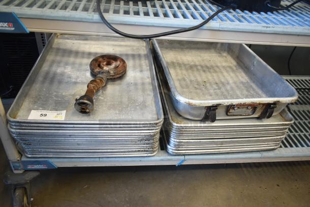 Stacks of full-size baking pans and a roasting pan on a shelf with visible wear; auction lot tag attached.