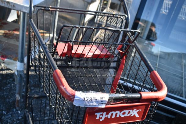 2-tier shopping cart with black metal frame and red handles, featuring a front TJ Maxx logo. Label indicates auction item 173.