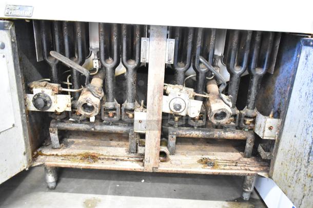 Pitco Frialator commercial gas fryer, exposed internal components, signs of rust and wear, Pitco label visible.