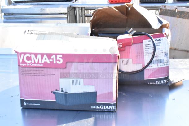 Two Little Giant VCMA-15 condensate removal pumps in original boxes, partially visible wiring, model number on label.