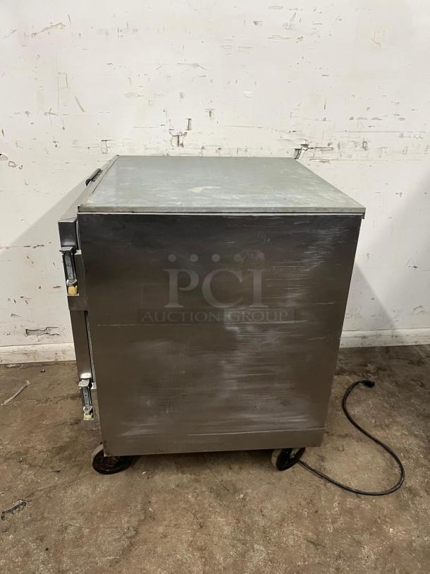 Beverage-Air 27" undercounter refrigerator, stainless steel, visible wear, on casters, power cord attached.