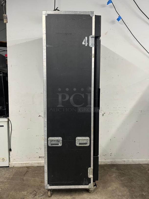 TRUE GDM-19T-LD refrigerated glass door merchandiser in a black travel case, with visible metal latches and wheels.
