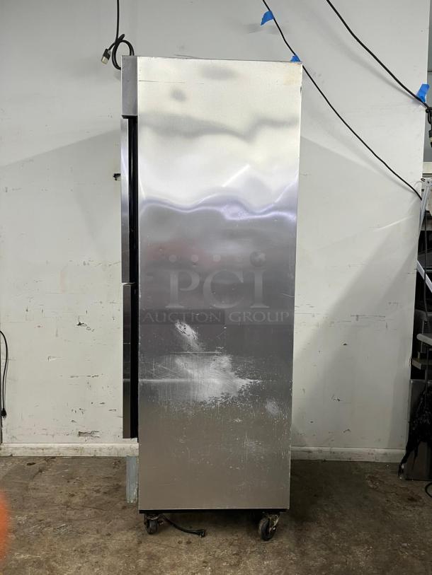 TRUE T-23-2 refrigerator with two left hinge solid doors, stainless steel finish. Shows signs of wear, 115V, on casters.