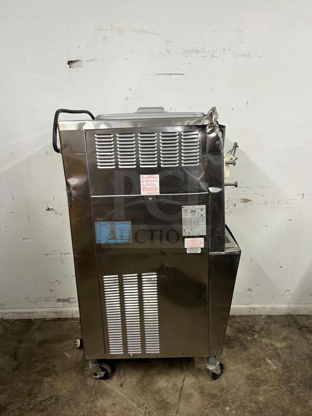 TAYLOR 794-33 soft serve ice cream machine, stainless steel, with visible labels and mounted on casters, in good condition.