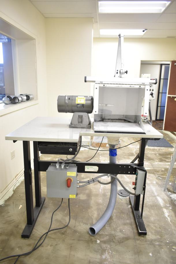 Baldor enclosed suction polishing machine with foot pedal on metal table, 208-230/460 volts, 3 phase.