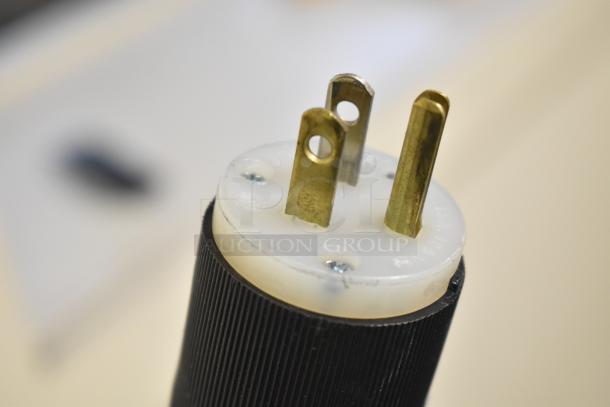 Close-up of a three-prong plug for the Baldor Enclosed Suction Polishing Machine, showing brass prongs and black casing.