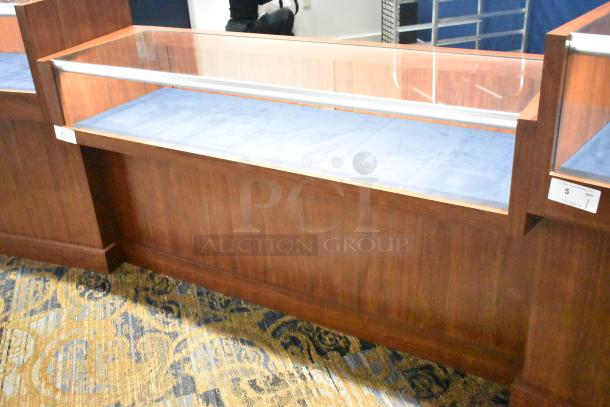 Wooden jewelry merchandising display case with glass top, blue interior lining. In good condition, includes visible item tags.