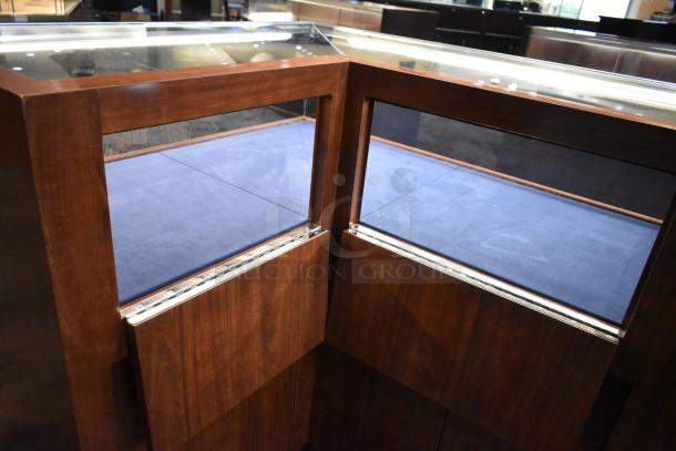 Wooden corner jewelry display case with glass top, dark wood finish, and blue fabric interior. Ideal for showcasing items.