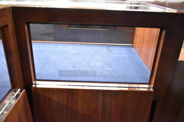 Wooden corner-style jewelry display case with glass panels and blue interior. Ideal for showcasing valuable pieces.