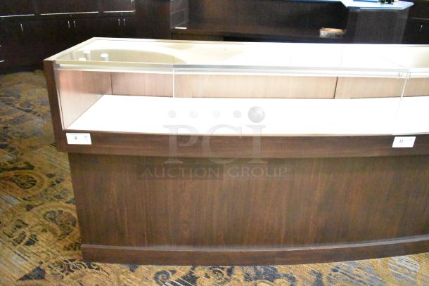 Wooden jewelry merchandising display case with glass top, dark wood finish, and visible shelf tag. Ideal for showcasing items.