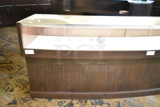 Wooden jewelry merchandising display case with glass top, dark wood finish, and visible shelf tag. Ideal for showcasing items.