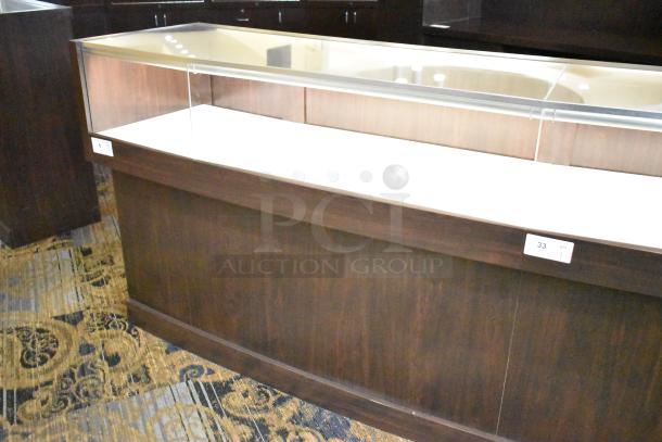 Wooden jewelry merchandising display case with glass top, dark wood finish, and shelf space. Tag indicates quantity: 1.
