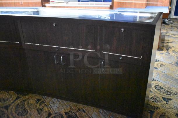 Wooden jewelry display case with glass top, dark finish, dual lockable cabinets, and metal handles, in good condition.