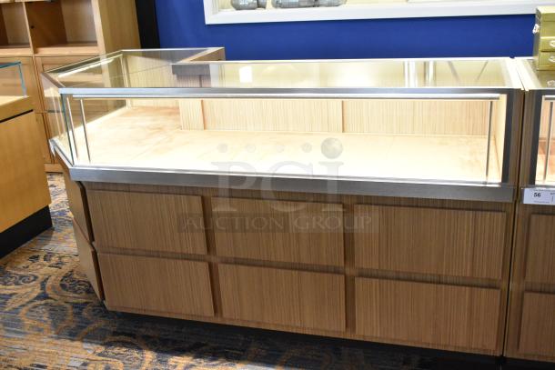 Wooden corner jewelry display case with glass top, beige interior, and metal trim, excellent condition, suitable for retail use.