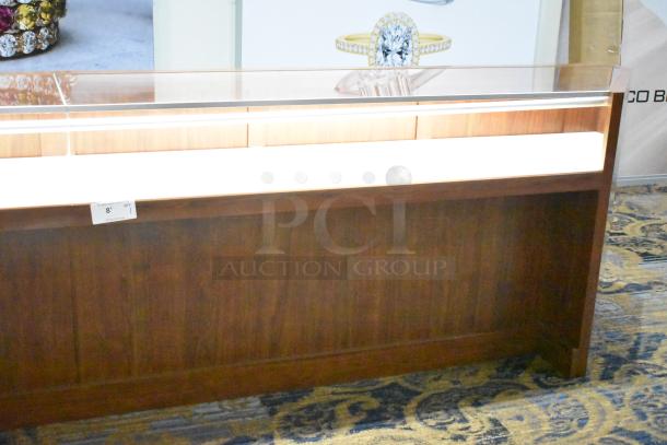 Wooden corner-style jewelry display case with glass top, two rear drawers, and rich finish. Ideal for showcasing items.