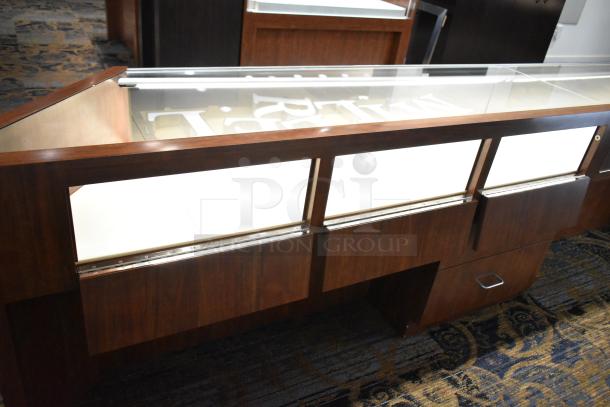 Wooden corner jewelry display case with glass top, two rear drawers, and wood finish. Ideal for showcasing merchandise.