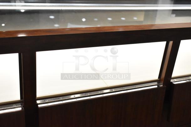 Wooden corner-style jewelry display case with glass top, two rear drawers, and sleek finish. Ideal for retail displays.