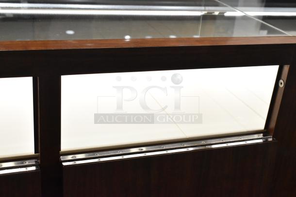 Wooden corner jewelry display case with glass top, two rear drawers, and metal hinge details. Ideal for showcasing items.