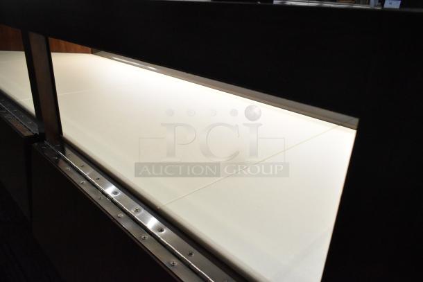 Wooden corner-style jewelry display case with two rear drawers, glass top, metal trim, and beige interior. Good condition.