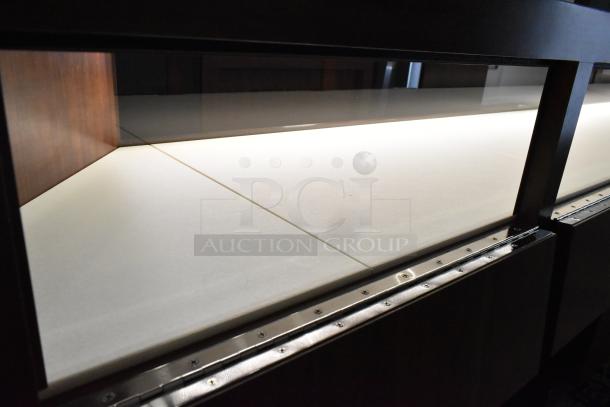 Wooden corner-style jewelry display case with glass front, two rear drawers, and a neutral interior surface.