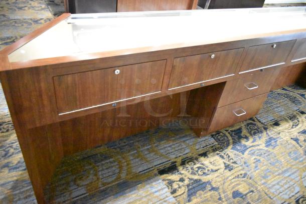 Wooden corner jewelry display case with glass top, two rear drawers, and three lockable front compartments.