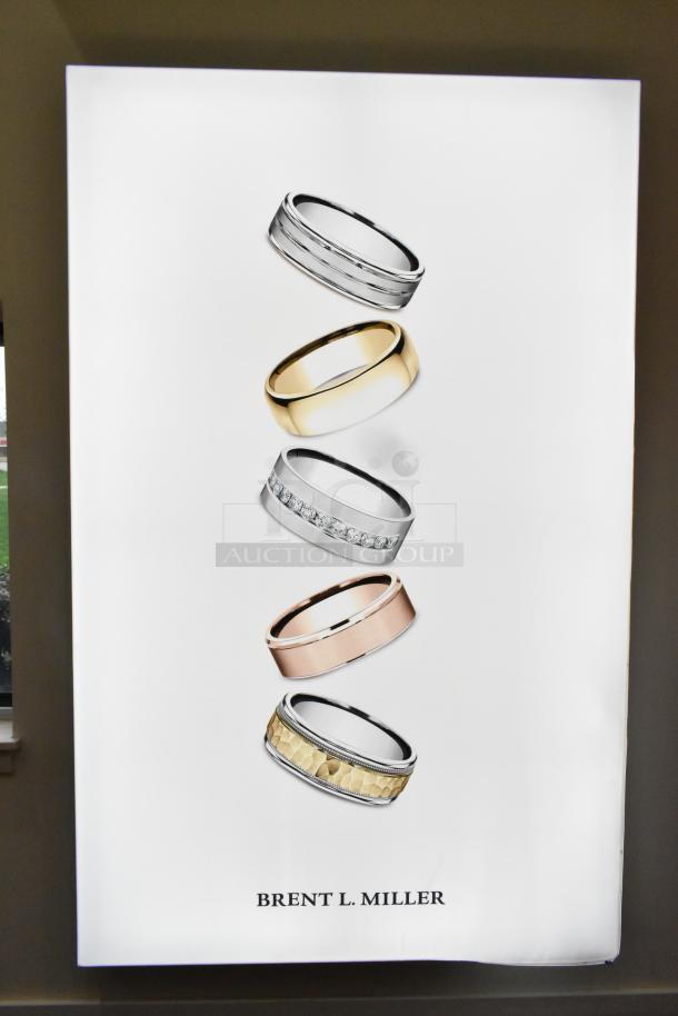 SEG Systems wall mount lighted picture display featuring rings. Operates on 110-277 volts. Text reads "BRENT L. MILLER".