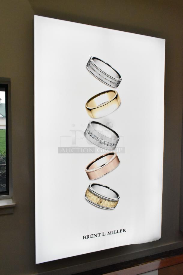 SEG Systems Wall Mount Lighted Picture Mount featuring rings, "Brent L. Miller" text, 110-277 volts, sleek condition.