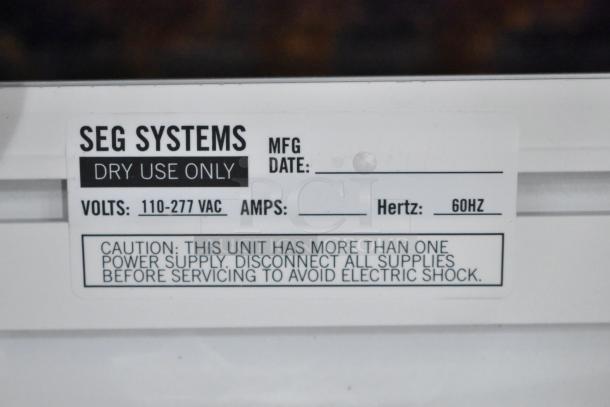 SEG Systems wall mount lighted picture mount, 110-277 volts, for dry use only, 60Hz, caution label visible.