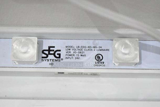 SEG Systems LB-EDG-6D-W6-24 wall mount lighted picture frame, 15W, 24V, UL listed. Model and spec labels visible.
