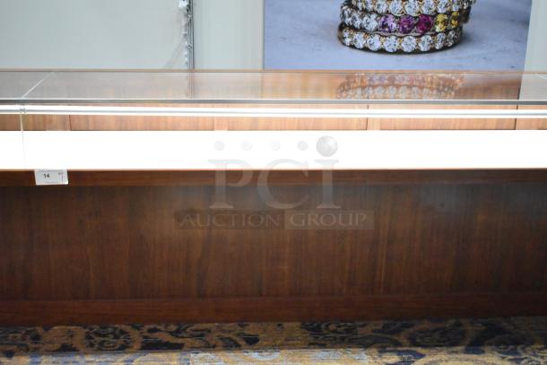 Lighted wooden jewelry display case with two drawers, glass top, and internal lighting. Great condition. Quantity tag visible.