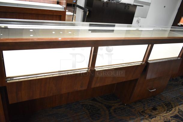 Lighted wooden jewelry display case with glass top, two drawers, excellent condition, suitable for retail merchandising.