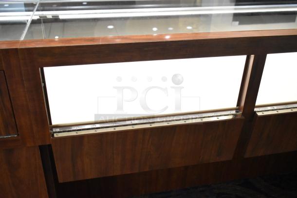 Lighted wooden jewelry display case with two drawers, glass top, dark wood finish, suitable for showcasing valuables.