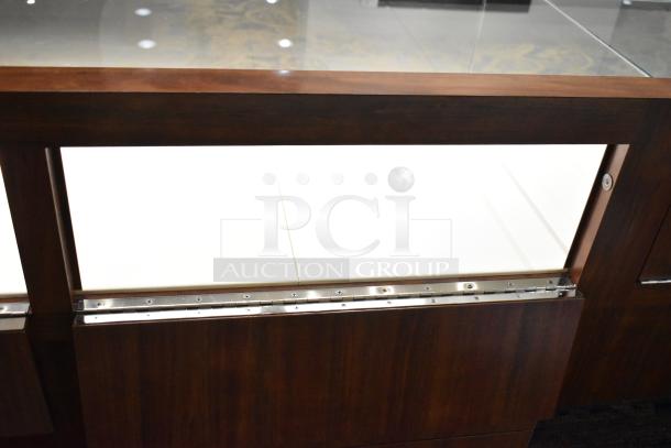 Lighted wooden jewelry display case with glass top, two drawers, and metal fixtures, in excellent condition.