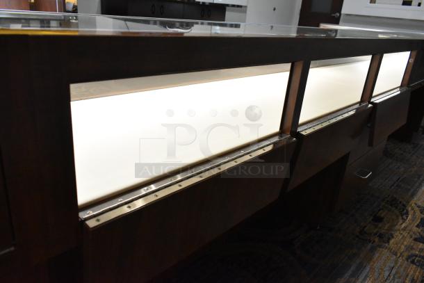 Lighted wooden jewelry display case with two drawers, sleek design, glass top, excellent condition for retail use.