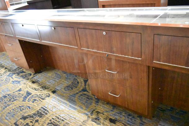 Lighted wooden jewelry display case with glass top, two locking drawers, and rich wood finish; ideal for merchandising.