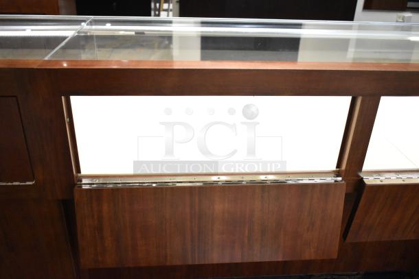 Lighted wooden jewelry display case with glass top and two drawers. Excellent condition, ideal for showcasing merchandise.