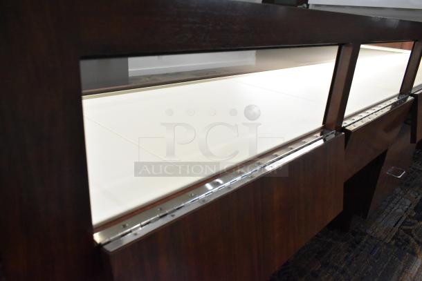 Lighted wooden jewelry merchandising display case with two drawers, showcasing a sleek design and rich wood finish.