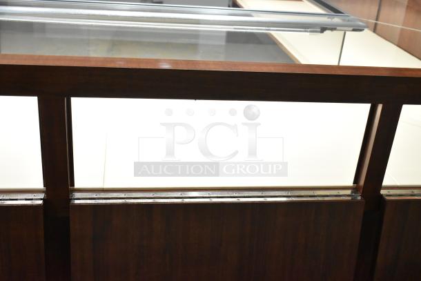 Lighted wooden jewelry merchandising display case with glass top; features a sleek, polished finish and metal accents.