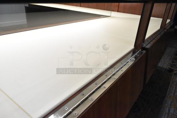 Lighted wooden jewelry display case with glass top, metal trim, and beige interior. Ideal for showcasing merchandise.