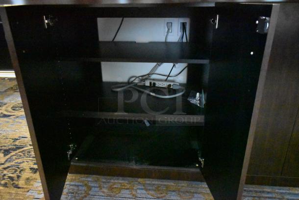 Wooden counter with 4 doors, featuring a dark finish and multiple shelves. Visible wiring inside, in used condition.