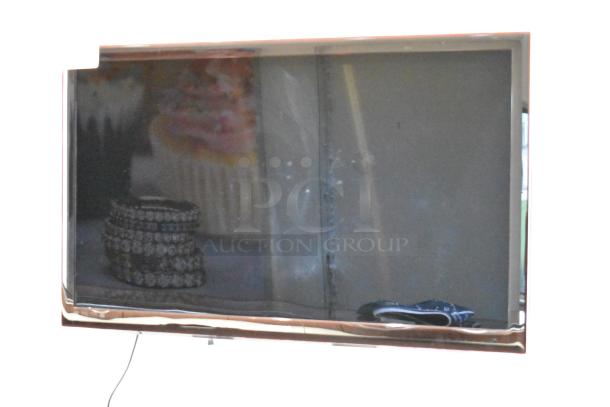 Samsung television on wall, reflective screen, moderate wear. Buyer must bring tools for removal.
