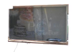 Samsung television on wall, reflective screen, moderate wear. Buyer must bring tools for removal.