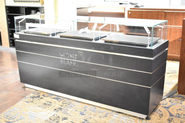 Black jewelry case with glass top, six rear drawers, modern design, Montblanc logo, requires removal with tools.