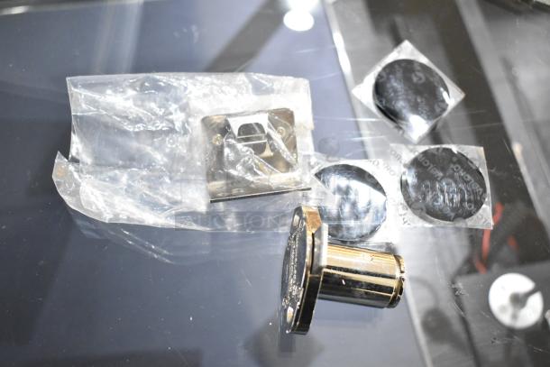 Chrome-finished hardware and installation accessories in sealed plastic bags, used for jewelry case assembly.