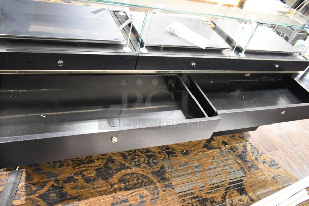 Jewelry case with six rear drawers, glass top, and lockable compartments. Good condition, requires tools and manpower for removal.